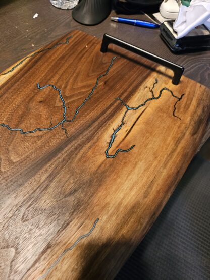 Lichtenberg wood-burned serving board with blue resin inlay and metal handles — Gentle Grain Workshop